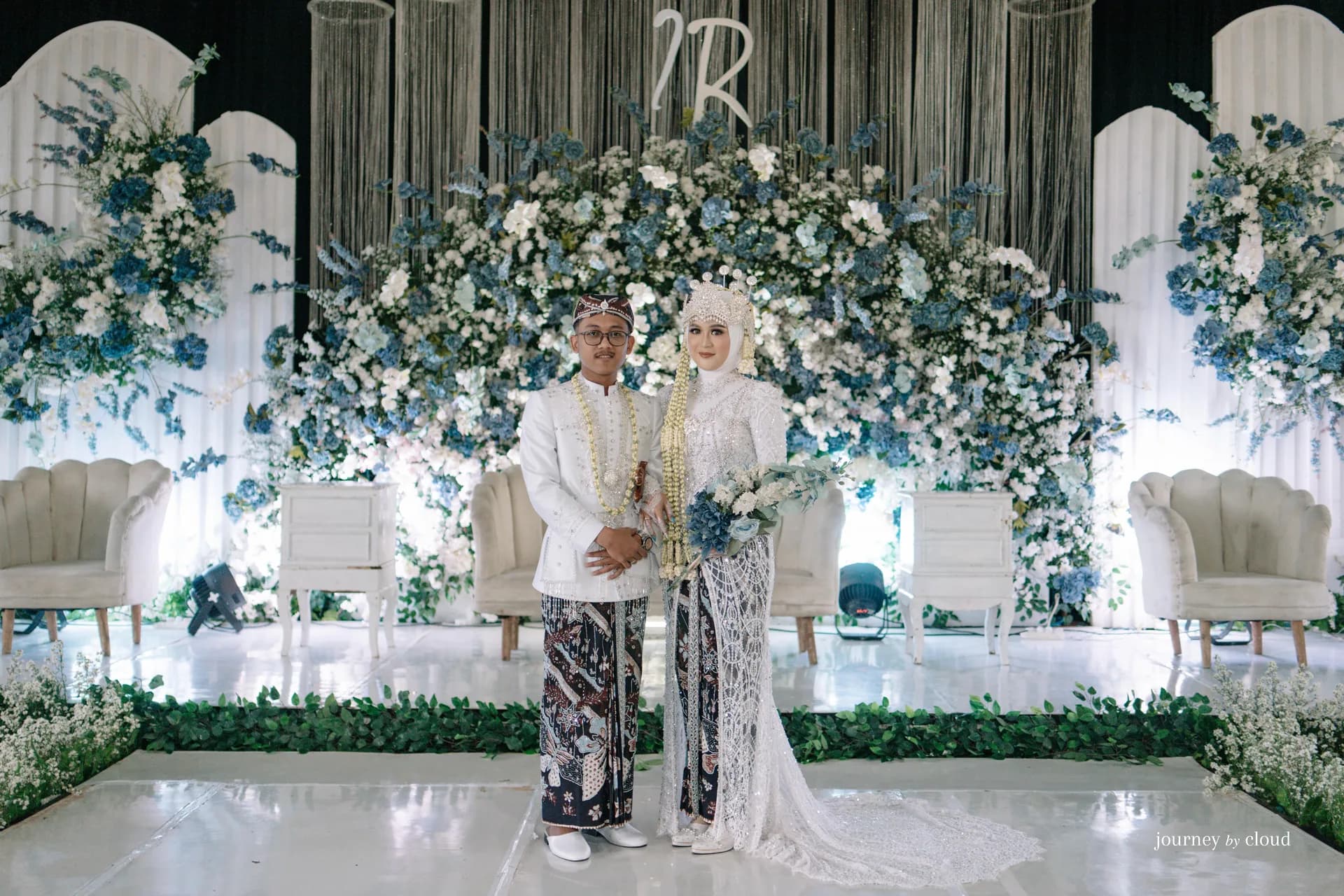 Pasangan pengantin dan para tamu tersenyum bersama